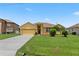 Inviting single-story home featuring a well-kept lawn and an attached two-car garage at 1457 Teal Dr, Kissimmee, FL 34759
