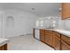 Open kitchen features wood cabinets, white appliances, and neutral tile floors at 1457 Teal Dr, Kissimmee, FL 34759