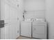 Laundry room features white washer and dryer, a wire storage shelf, and neutral flooring at 1457 Teal Dr, Kissimmee, FL 34759