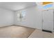 Bright living room featuring neutral carpet, large window, and a white front door at 1457 Teal Dr, Kissimmee, FL 34759