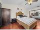Cozy bedroom featuring wood floors, wardrobe, bedside table, and a ceiling fan for added comfort at 1547 Farrindon Cir # 1547, Lake Mary, FL 32746