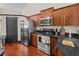 Modern kitchen with stainless steel appliances, wood cabinets, and dark granite countertops at 1547 Farrindon Cir # 1547, Lake Mary, FL 32746