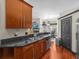 Stylish kitchen with stainless steel dishwasher, wood cabinets, and view into the dining area at 1547 Farrindon Cir # 1547, Lake Mary, FL 32746