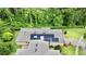 Overhead view displaying the house with solar panels, lush trees, and well-kept lawn at 1573 Amber Leaf Cir, Ocoee, FL 34761