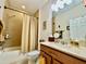 Bright bathroom with a vanity, a toilet, tiled shower with curtain, and updated fixtures at 1573 Amber Leaf Cir, Ocoee, FL 34761