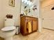 Cozy bathroom featuring a toilet, vanity, light fixtures, and wood-look tile flooring at 1573 Amber Leaf Cir, Ocoee, FL 34761