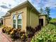 Exterior side view showing colorful landscaping and arched window at 1573 Amber Leaf Cir, Ocoee, FL 34761