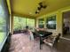 Cozy screened porch with brick flooring, ceiling fans, relaxing hammock, and lush backyard scenery at 1573 Amber Leaf Cir, Ocoee, FL 34761
