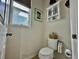 Clean, organized toilet room with a small window and a cabinet at 1573 Amber Leaf Cir, Ocoee, FL 34761