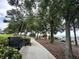 Park featuring a bench along a walking path lined with mature trees and lush landscaping at 1573 Amber Leaf Cir, Ocoee, FL 34761
