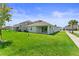 Sprawling backyard featuring ample green space, a covered patio, and lush landscaping at 19105 Planetree St, Orlando, FL 32827