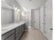 Neutral-toned bathroom featuring double vanity, large mirror, and walk-in shower at 19105 Planetree St, Orlando, FL 32827
