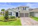 Charming two-story home with well-manicured lawn, neutral shutters, and two car garage at 19105 Planetree St, Orlando, FL 32827