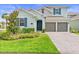 Charming two-story home with manicured lawn and a two-car garage on a sunny day at 19105 Planetree St, Orlando, FL 32827