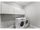 Functional laundry room with white cabinets, a washer, and a dryer at 19105 Planetree St, Orlando, FL 32827