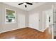 Bedroom featuring hardwood flooring, a ceiling fan, and ample closet space in a neutrally decorated color palette at 2009 E Grant St, Orlando, FL 32806