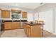 Charming kitchen featuring an island with granite countertop, stainless steel appliances and wooden cabinets at 2009 E Grant St, Orlando, FL 32806