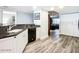 Cozy kitchen with stainless steel dishwasher, black countertop, white cabinetry, and laminate floors at 2055 S Atlantic Ave # 505, Daytona Beach, FL 32118