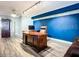 Office features a large desk, blue accent wall, and laminate wood floors at 2055 S Atlantic Ave # 505, Daytona Beach, FL 32118