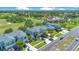 Aerial view showcasing the townhomes with well-kept lawns, and golf course, under clear, blue skies at 20610 Maxim Pkwy, Orlando, FL 32833