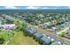 Expansive aerial showing townhomes near a neighborhood with lush trees, homes, and clear blue skies at 20610 Maxim Pkwy, Orlando, FL 32833