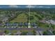 Wide aerial captures golf course views, blue townhomes, and sunny skies at 20610 Maxim Pkwy, Orlando, FL 32833