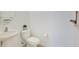 Neutral-toned powder room featuring a pedestal sink, toilet and decorative wall hangings at 20610 Maxim Pkwy, Orlando, FL 32833
