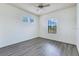 Bright bedroom featuring hardwood flooring, two windows, a ceiling fan and white walls at 20610 Maxim Pkwy, Orlando, FL 32833
