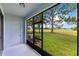 Covered patio provides views of a lush lawn, screened windows, and a door to access the backyard at 20610 Maxim Pkwy, Orlando, FL 32833