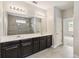 Bathroom with double vanity, dark wood cabinets, a large mirror, and tiled shower at 2066 Cresswell St, Ocoee, FL 34761