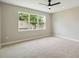 Bright, empty bedroom featuring neutral carpet, a ceiling fan, and a large window at 2066 Cresswell St, Ocoee, FL 34761