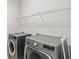 Modern laundry room featuring updated washer and dryer with wire rack shelving above at 2066 Cresswell St, Ocoee, FL 34761