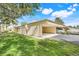 Exterior view of carport, highlighting lush lawn, mature trees, and covered parking at 208 Sonora Drive # 208, Casselberry, FL 32707