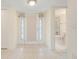 Bright foyer featuring tile flooring, decorative glass doors, and convenient access to a bathroom at 208 Sonora Drive # 208, Casselberry, FL 32707