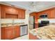 Well-equipped kitchen featuring granite counters, wood cabinets, stainless appliances and tile flooring at 208 Sonora Drive # 208, Casselberry, FL 32707