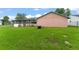 A spacious backyard with vibrant green grass that extends to a screened in porch with a firepit at 2309 Cilantro Dr, Orlando, FL 32837