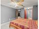 A gray-walled bedroom with a ceiling fan, features a queen-size bed and multiple access doors to the adjacent spaces at 2309 Cilantro Dr, Orlando, FL 32837