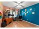 Bedroom has wood floor, ceiling fan, two-tone paint and plenty of wall decorations at 2309 Cilantro Dr, Orlando, FL 32837