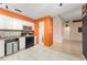 Bright kitchen with white cabinets, black range, and tile floor opening up into the living area at 2309 Cilantro Dr, Orlando, FL 32837