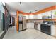 Bright kitchen features white cabinets, stainless steel refrigerator, black range and tiled floor at 2309 Cilantro Dr, Orlando, FL 32837