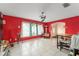 A bright living room with tiled floor, red accent walls, and large windows that fill the space with natural light at 2309 Cilantro Dr, Orlando, FL 32837