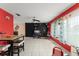 A living room with tile flooring, bright red walls, a black accent wall, and a ceiling fan, providing ample light at 2309 Cilantro Dr, Orlando, FL 32837