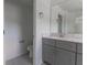This well-lit bathroom features modern vanity with gray cabinets, white counter top, sink, and tile flooring at 2460 Reading Trl, Kissimmee, FL 34746