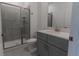 Modern bathroom featuring glass-enclosed shower, gray vanity with white countertops, providing a spa-like retreat at 2460 Reading Trl, Kissimmee, FL 34746