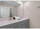 Bathroom vanity featuring double sinks, gray cabinets, a neutral countertop and large mirror at 2460 Reading Trl, Kissimmee, FL 34746