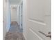 Upstairs hallway with neutral carpet and white doors leading to various rooms of the home at 2460 Reading Trl, Kissimmee, FL 34746