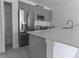 Open kitchen with stainless steel appliances, modern gray cabinetry, a spacious pantry, and a kitchen island at 2460 Reading Trl, Kissimmee, FL 34746