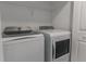 Bright laundry room features a white washer and dryer, as well as a wire rack shelf at 2460 Reading Trl, Kissimmee, FL 34746