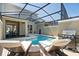Pool with poolside lounge chairs, grill, and covered patio with dining at 2460 Reading Trl, Kissimmee, FL 34746