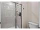 Shower with glass doors and gray tile in a neutral-toned bathroom at 2460 Reading Trl, Kissimmee, FL 34746